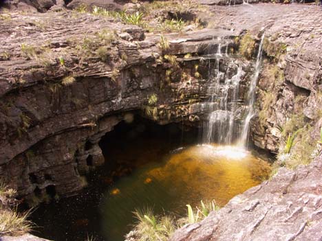 a 
sinkhole with a waterfall dropping into it on top of roraima in venezuela